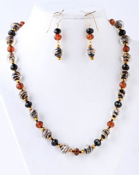 A necklace and earrings set with black, brown and orange beads.