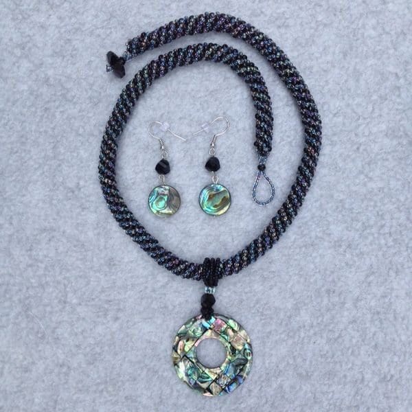 A necklace and earrings set with green flowers.