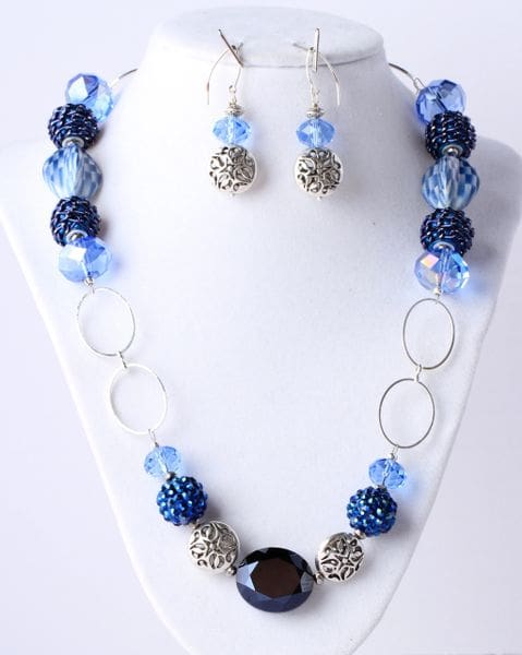 A necklace and earrings set with blue beads.