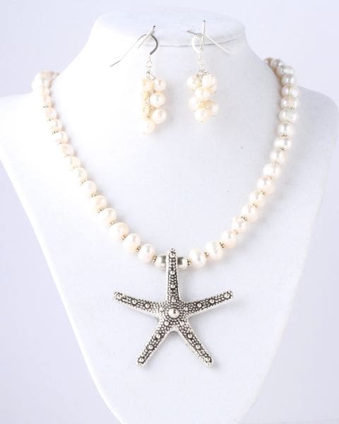 A necklace and earrings set with pearls and starfish.