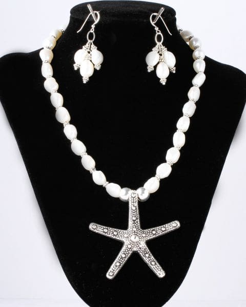 A necklace and earrings set with pearls and silver starfish.