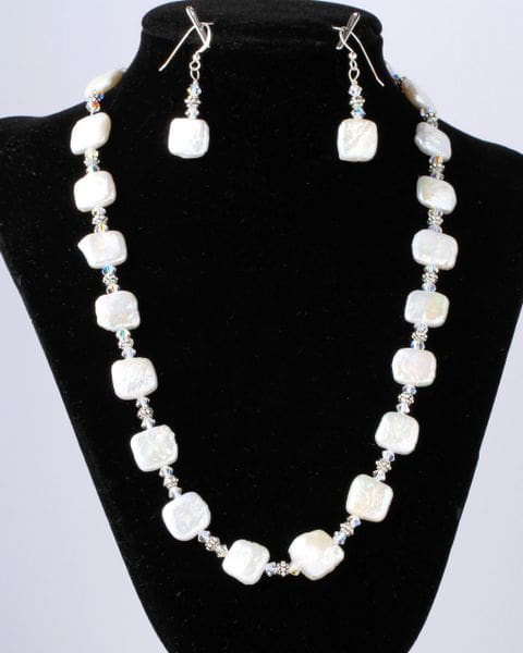 A necklace and earrings set of white beads.