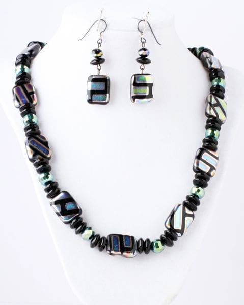 A necklace and earrings set with black, white and green beads.