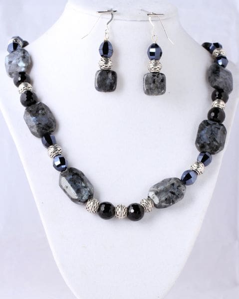 A necklace and earrings set with black stones.