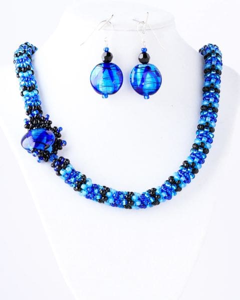 A necklace and earrings set made of blue glass beads.