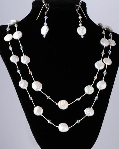 A necklace and earrings set with white pearls.