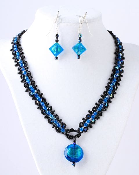 A necklace and earrings set with blue beads.