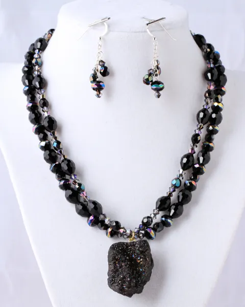 A necklace and earrings set with black beads.